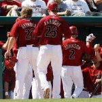 Arizona Diamondbacks Mark Reynolds (27), Adam LaRoche (25) and Kelly Johnson (2) are congratulated by teammates as they enter the dugout after scoring against the Milwaukee Brewers on a three-run double by Miguel Montero in the third inning of a Cactus League spring training baseball game in Tucson, Ariz., on Sunday, March 28, 2010. (AP Photo/Ed Andrieski)