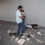 People walk over bricks from a wall that fell in downtown Calexico, Calif. after an earthquake struck the area Sunday, April 4, 2010. The 7.2-magnitude quake struck at 3:40 p.m. about 19 miles southeast of Mexicali, a bustling commerce center on the Mexican side of the border where trucks carrying goods cross into California. (AP Photo/Denis Poroy)