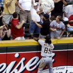 Pittsburgh Pirates' Lastings Milledge (85) tries in vain to catch a home run ball hit by Arizona Diamondbacks' Chris Young, as a fan, upper center, celebrates catching it, in the fourth inning of a baseball game Sunday, April 11, 2010, in Phoenix. The hit was a three-run shot for Young and the Diamondbacks scored 13 runs in the inning. (AP Photo/Ross D. Franklin)