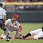 Philadelphia Phillies second baseman Chase Utley, center, tags out Arizona Diamondbacks' Justin Upton, right, to complete a double play as umpire Jerry Meals, left, looks on in the first inning of a baseball game Saturday, April 24, 2010, in Phoenix. (AP Photo/Paul Connors)