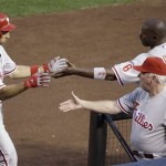 Philadelphia Phillies' Raul Ibanez, left, returns to the dugout and is greeted by teammate Ryan Howard, top right, and manager Charlie Manuel, bottom right, after hitting a solo home run off Arizona Diamondbacks pitcher Ian Kennedy in the seventh inning of a baseball game Saturday, April 24, 2010, in Phoenix. (AP Photo/Paul Connors)