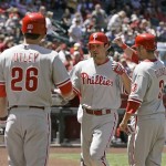 Philadelphia Phillies' Greg Dobbs, center, is congratulated by teammates Chase Utley, left, and Ross Gload, right, at homeplate after Dobbs hit a two-run home run off Arizona Diamondbacks pitcher Rodrigo Lopez in the first inning of a baseball game Sunday, April 25, 2010, in Phoenix. (AP Photo/Paul Connors)