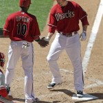 Arizona Diamondbacks' Mark Reynolds, right, is congratulated by teammate Justin Upton, center, in front of Philadelphia Phillies catcher Carlos Ruiz, left, as Reynolds steps on home plate after hitting a three-run home run off Phillies pitcher Kyle Kendrick in the fifth inning of a baseball game Sunday, April 25, 2010, in Phoenix. (AP Photo/Paul Connors)