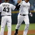 Colorado Rockies' Carlos Gonzalez, right, is congratulated by third base coach Rich Dauer as he rounds the bases after hitting a solo home run against the Arizona Diamondbacks during the first inning of a baseball game on Monday, April 26, 2010, in Denver. (AP Photo/David Zalubowski)