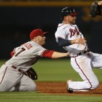 Atlanta Braves' Martin Prado, right, is tagged put by Arizona Diamondbacks' Mark Reynolds, left, after being caught between second and third in the third inning of a baseball game Friday, May 14, 2010, in Atlanta. (AP Photo/John Bazemore)