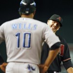 Arizona Diamondbacks' Mark Reynolds laughs as he talks with Toronto Blue Jays' Vernon Wells, who advanced to third on a passed ball during the second inning of an interleague baseball game Saturday, May 22, 2010, in Phoenix. (AP Photo/Ralph Freso)