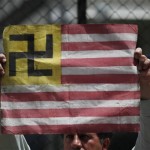 A protester holds a sign in the likeness of the US flag at a demonstration against Arizona's new immigration law outside the US embassy in Mexico City, Wednesday July 28, 2010. (AP Photo/Alexandre Meneghini)
