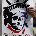 A protester holds a sign at a demonstration against Arizona's new immigration law outside the US embassy in Mexico City, Wednesday July 28, 2010. (AP Photo/Alexandre Meneghini)