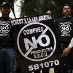 Demonstrators protest Arizona's new immigration law outside the US embassy in Mexico City, Wednesday July 28, 2010. The banner and T-shirts read in Spanish "Boycott Arizona's law, don't buy US products." (AP Photo/Alexandre Meneghini)