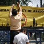 A protester hangs a banner that reads in Spanish "Against Arizona's law" at a protest against Arizona's new immigration law outside the US embassy in Mexico City, Wednesday July 28, 2010. (AP Photo/Alexandre Meneghini)
