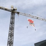 After climbing a building crane, protesters hang a sign against Arizona immigration bill SB1070 and the 287(g) criminal immigrant fingerprinting system Wednesday, July 28, 2010 in Phoenix. The U.S. District Court judge struck down portions of the bill before it goes into effect Thursday. (AP Photo/Ross D. Franklin)