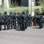 Police stand guard while people protest SB1070, which went into effect in limited fashion Thursday, July 29. (Jim Cross/KTAR)