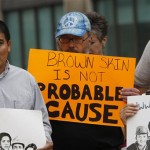 Ike Thacker, center, holds a sign as he joins others in protesting the Arizona immigration law outside the federal courthouse in Louisville, Ky., Thursday, July 29, 2010. (AP Photo/Ed Reinke)
