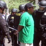 A marcher is arrested while marching against SB 1070, which went into effect in limited fashion Thursday, July 29. (Kevin Tripp/KTAR) 