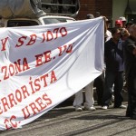 People hold a banner that reads in Spanish "The law SB 1070 in Arizona, USA, is terrorist" outside the U.S. embassy in San Salvador, El Salvador, Thursday July 29 , 2010. A U.S. federal judge blocked on Wednesday the most controversial parts of Arizona's immigration law from taking effect. The overall law will still take effect Thursday but without the provisions that angered opponents, including sections that required immigrants to carry their papers and law officers to check on a person's immigration status while enforcing other laws. (AP Photo/Luis Romero)