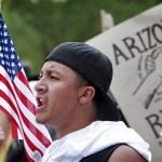 Julio Fierro Jr., 19, of Tucson, protests Thursday, July 29, 2010 in Phoenix to rally against Arizona's new immigration law, SB1070. Opponents of Arizona's immigration crackdown went ahead with protests Thursday despite a judge's ruling that delayed enforcement of most the law. (AP Photo/Matt York)