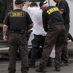 Maricopa County Sheriff's deputies processes a male who was arrested during the sheriff department's crime suppression sweeps Thursday, July 29, 2010 in Phoenix. (AP Photo/Matt York)