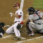 Arizona Diamondbacks' Adam LaRoche, left, is tagged out trying to score by Washington Nationals' Ivan Rodriguez during the second inning of a baseball game Tuesday, Aug. 3, 2010, in Phoenix. (AP Photo/Ross D. Franklin)