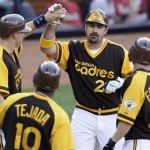 The San Diego Padres' Adrian Gonzalez, second from right, is greeted by teammates David Eckstein, right, Miguel Tejada, second from left, and Nick Hundley after hitting a grand slam home run against the Arizona Diamondbacks in the eighth inning during their baseball game Thursday, Aug. 26, 2010 in San Diego. (AP Photo/Gregory Bull)
