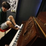 In this Aug. 26, 2010 photo, pianist Liu Wei takes off one of socks to play a piano before his practice session in Shanghai. The 23-year-old, whose arms were amputated after a childhood accident, plays the piano with his toes. Liu was thrust into the limelight earlier this month when he performed on "China's Got Talent," the Chinese version of the TV show that helped make Britain's Susan Boyle a singing star. (AP Photo/Eugene Hoshiko)

