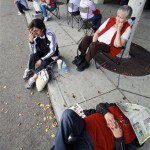 People sleep on the sidewalk as thousands of people wait in line at the Los Angeles Convention Center for free mortgage help in downtown Los Angeles on Thursday, Sept. 30, 2010. A nonprofit group called the Neighborhood Assistance Corporation of America is offering the chance to restructure their home loans at lower rates. (AP Photo/Damian Dovarganes)