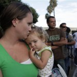 Jamie Franklin holds her daughter, Lillie, while waiting in line with thousands of others to get free mortgage help in downtown Los Angeles on Thursday Sept.30, 2010. A nonprofit group called the Neighborhood Assistance Corporation of America is offering the chance to restructure their home loans at lower rates. An estimated 30,000 people are expected to attend the five-day event. (AP Photo/Nick Ut)