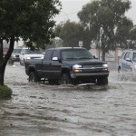 Traffic tries to navigate a flooded street after violent storms passed through Tuesday, Oct. 5, 2010 in Phoenix. (AP Photo/Ross D. Franklin)

