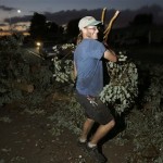 Todd Greenly, of "2 Idiots In A Tree" lawn service, picks up fallen tree debris from a street after violent storms passed through Tuesday, Oct. 5, 2010 in Mesa, Ariz. (AP Photo/Ross D. Franklin)

 
