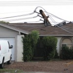 A downed power line rest on top of a home after violent storms passed through Tuesday, Oct. 5, 2010 in Mesa, Ariz. (AP Photo/Ross D. Franklin)
