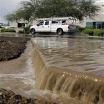 Floodwaters cascade over sidewalks from the streets after violent storms passed through the area on Tuesday, Oct. 5, 2010, in Phoenix. (AP Photo/Ross D. Franklin)
