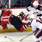 New Jersey Devils' Adam Mair, left, is tripped by Phoenix Coyotes' Kyle Turris (91) as Coyotes' Taylor Pyatt looks on during the second period of an NHL hockey game Wednesday, Dec. 15, 2010, in Newark, N.J. (AP Photo/Bill Kostroun)