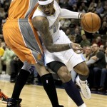 Denver Nuggets small forward Carmelo Anthony (15) pushes past Phoenix Suns center Robin Lopez (15) during the first quarter of an NBA basketball game in Denver, Tuesday, Jan. 11, 2011. (AP Photo/Barry Gutierrez)