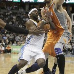 Denver Nuggets point guard Ty Lawson (3) wrestles through traffic to score past Phoenix Suns center Robin Lopez (15) during the first half of an NBA basketball game in Denver Tuesday, Jan. 11, 2011. (AP Photo/Barry Gutierrez)