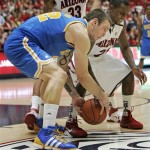 UCLA's Reeves Nelson, left, and Arizona's Kyle Fogg struggle for control of a loose loose during the second half of an NCAA college basketball game at McKale Center in Tucson, Ariz., Thursday, Jan. 27, 2011. Arizona won 85-74. (AP Photo/John Miller)