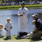 Stuart Appleby of Australia sits on the fourth green with his children during the Par 3 competition before the Masters golf tournament Wednesday, April 6, 2011, in Augusta, Ga. At center is caddie Scott Sajtinac. (AP Photo/David J. Phillip)