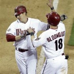 Arizona Diamondbacks' Kelly Johnson, left, is congratulated by teammate Willie Bloomquist, right, after Johnson hit a three-run home against the Cincinnati Reds in the eighth inning of an MLB baseball game, on Opening Day for the Diaondbacks Friday, April 8, 2011, in Phoenix. The Diamondbacks 13-2.(AP Photo/Paul Connors)