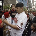 Arizona Diamondbacks fan Alex Ramirez carries his two-year-old son Ezra through the turnstiles as he arrives to watch the Diamondbacks against the Cincinnati Reds in an MLB baseball game, on Opening Day for the Diaondbacks Friday, April 8, 2011, in Phoenix. (AP Photo/Paul Connors)