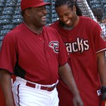 Cardinals WR Larry Fitzgerald takes instruction from D-backs hitting coach Don Baylor during batting practice at Chase Field Tuesday, April 12, 2011. (Adam Green/Arizonasports.com)