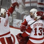 Detroit Red Wings' Tomas Holmstrom, middle, of Sweden, celebrates his goal against the Phoenix Coyotes with teammates Pavel Datsyuk (13), of Russia, and Mike Modano during the first period in Game 4 of a first-round NHL hockey Stanley Cup playoffs series Wednesday, April 20, 2011, in Glendale, Ariz. (AP Photo/Ross D. Franklin)
