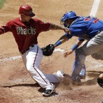 Arizona Diamondbacks' Ryan Roberts, left, scores ahead of the tag by Chicago Cubs' Geovany Soto, middle, as umpire Tony Randazzo looks on during the fourth inning of a baseball game Sunday, May 1, 2011, in Phoenix. (AP Photo/Ross D. Franklin)
