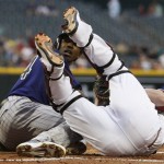 Colorado Rockies' Dexter Fowler, left, is tagged out at home plate as Arizona Diamondbacks' Miguel Montero tumbles over during the first inning of an MLB baseball game, Thursday, May 5, 2011, in Phoenix. (AP Photo/Ross D. Franklin)