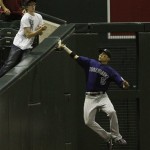 Colorado Rockies' Carlos Gonzalez (5) makes a jumping catch on a foul ball hit by Arizona Diamondbacks' Stephen Drew during the eighth inning of an MLB baseball game Thursday, May 5, 2011, in Phoenix. (AP Photo/Ross D. Franklin)