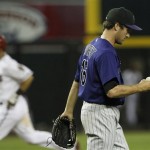 Colorado Rockies' Huston Street, right, looks at a new ball after giving up a home run to Arizona Diamondbacks' Gerardo Parra, left, during the ninth inning of an MLB baseball game Thursday, May 5, 2011, in Phoenix. (AP Photo/Ross D. Franklin)