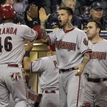 Arizona Diamondbacks' Juan Miranda, left, is greeted by teammates Ryan Roberts, center, and Miguel Montero, after scoring on a hit by Kelly Johnson in the ninth inning against the San Diego Padres during their baseball game Friday, May 6, 2011, in San Diego. (AP Photo/Gregory Bull)