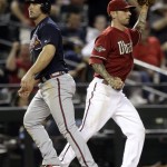 Atlanta Braves' Dan Uggla, left, looks to the dugout after he was thrown out advancing to third on a hit by teammate Freddie Freeman as Arizona Diamondbacks' Ryan Roberts, right, looks away during the sixth inning of a baseball game on Wednesday, May 18, 2011, in Phoenix. (AP Photo/Matt York)