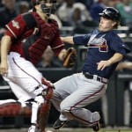 Atlanta Braves' Nate McLouth, right, scores on an RBI-double by teammate Brooks Conrad as Arizona Diamondbacks catcher Miguel Montero, left, waits for the throw during the seventh inning of a baseball game on Wednesday, May 18, 2011, in Phoenix. (AP Photo/Matt York)