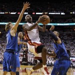 Miami Heat's LeBron James drives between Dallas Mavericks' Dirk Nowitzki (41) and Tyson Chandler (6) during the second half of Game 1 of the NBA Finals basketball game Tuesday, May 31, 2011, in Miami. (AP Photo/David J. Phillip; Pool)