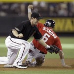 Arizona Diamondbacks shortstop Stephen Drew, left, misses the throw as Washington Nationals' Ian Desmond, right, steals second base, and then went on to take third on the errant throw, in the first inning of an MLB baseball game on Saturday, June 4, 2011, in Phoenix. (AP Photo/Paul Connors)
