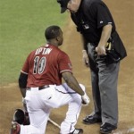 Homeplte umpire Rob Drake, right, checks on the condition of Arizona Diamondbacks' Justin Upton, left, after Upton was hit by a pitch from Washington Nationals' Jason Marquis in the sixth inning of an MLB baseball game on Sunday, June 5, 2011, in Phoenix. Marquis and Nationals manager Jim Riggleman were both ejected from the game. (AP Photo/Paul Connors)
