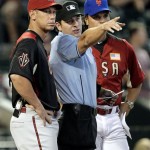 U.S. manager Mike Piazza, right, and World manager Luis Gonzalez, left, talk with home plate umpire Ben May prior to the All-Star Futures baseball game Sunday, July 10, 2011, in Phoenix. (AP Photo/Matt York)